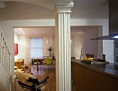 White-painted wooden column in foyer and view of living space through wide doorway