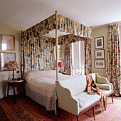 Four-poster bed with floral pattern and matching curtains in traditional bedroom