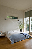 Minimalist bedroom with access to the terrace and wooden floor