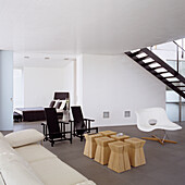 Minimalist living room with white designer chair and small wooden side tables