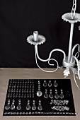 Chandelier hanging above organised glass decorations on black cloth