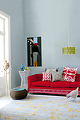 Cushions on red sofa and pendant retro lamp in minimalist living room