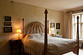 Bett mit Holzrahmen und Nachttischen in einem Schlafzimmer mit Vintage-Dekor