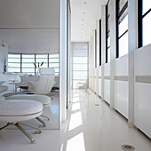 Modern living room in white with windows and leather armchairs