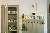 Vintage kitchen cabinet with ceramic storage jars and open crockery cupboard