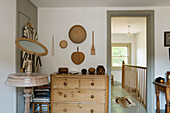 Room with wooden chest of drawers and antique mirror stand, view of staircase