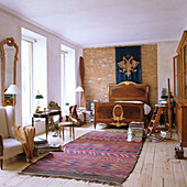 Large bedroom with opulent bed and patterned carpet on wooden floor