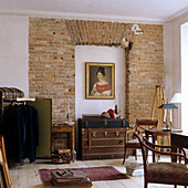 Room with brick wall, antique furniture and paintings