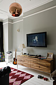 Living room with TV, lowboard and copper-coloured pendant light