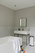 Bathroom with white furniture, mirror and walls in beige and with mosaic tiles