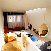 Living room with hanging chair, orange armchairs and cowhide rug