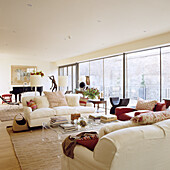 living room with white sofas, large window and grand piano