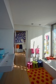 Colourful bathroom suitable for children with long sink and many colour accents