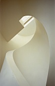 Staircase corkscrewing upwards with solid, white balustrade