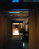 View of passage with wooden beams and interior room through open front door