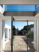 View of terrace and forecourt through open glass door in contemporary apartment building