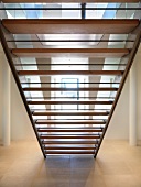 Bottom view of staircase with wooden treads in modern foyer