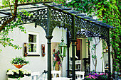 Patio with wrought-iron pergola and white garden furniture