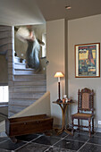 Treppe im Hausflur mit historischem Stuhl und Vintage-Plakat