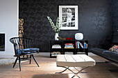 Modern living room with black patterned wallpaper and designer furniture