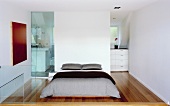 Modern bedroom with partition and floor-to-ceiling glass door