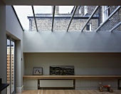 Minimalist living space in modern extension with glass roof