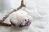 Candle holder made of ice with frozen berries