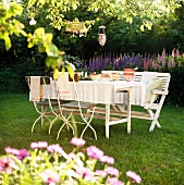 Gedeckter Tisch in einem sommerlichen Garten