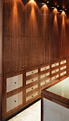 Wooden, fitted cupboards with reflections from ceiling spots