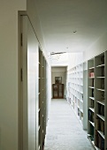 Corridor with white, fitted shelving on both sides