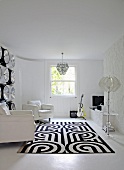 Black and white patterned rug in front of white leather armchairs in cool living room