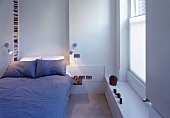 Bed with grey bed linen in white bedroom