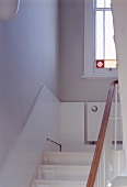 Ausschnitt eines Treppenhauses mit halbhoher Holzverkleidung in Weiß