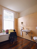 Drying rack in bathtub and sink on modern, wooden installation against wall