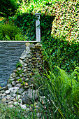 Slate and cobble garden wall abutting ivy-covered wall