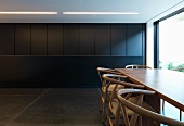 Dining area with classic chairs and monolithic, dark grey kitchen counter