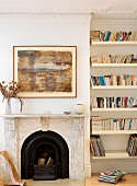 Open fireplace with marble surround and bookcase in niche