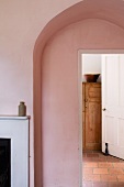Simple arch with view of cupboard through integrated, open door