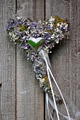 Dried flower heart against wooden background (top view)