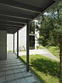 Überdachter Eingangsbereich mit Pflasterbelag an modernem Gebäude