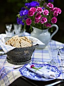 Table set with bread basket and with a bouquet of flowers