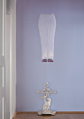 Floating artwork and cast iron umbrella stand against lilac-coloured wall in period hallway