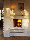 Rustic stone wall with blazing fire in a built-in fireplace