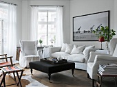 White, upholstered furniture and black coffee table