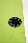 Black floral linocut template on green fabric