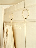 Heart-shaped, metal hooks on wooden wall