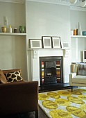 Rug with abstract floral pattern and brown leather couch in front of open fireplace