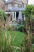 View through grasses of dining area on terrace of country house