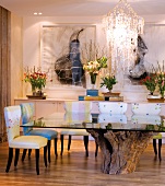 Glass table with rustic base made from tree trunk and upholstered chairs in dining room
