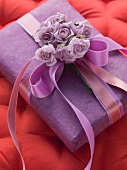 A gift box decorated with a bow and roses